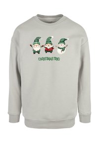 Sweatshirt de culoare gri deschis, cu o grafică pe partea din față care prezintă trei gnomi jucăuși îmbrăcați în verde și roșu, având textul "TRIOUL DE CRĂCIUN" dedesubt.