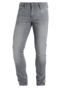 Jeans de denim gris con un ajuste slim, que cuentan con una cintura de altura media, cinco bolsillos y una clásica cremallera de botones. La tela tiene una textura suave.