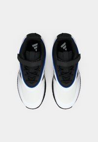 Ténis desportivos em preto e branco com detalhes em azul, textura em malha e fecho por tira. Solas de borracha planas, bico arredondado e lingueta acolchoada.