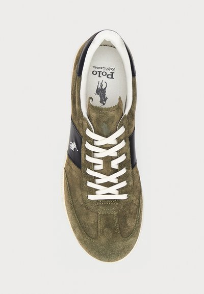 Baskets en daim vert olive avec des accents en cuir noir, lacets blancs, bout arrondi et détail de logo sur la languette et le côté.