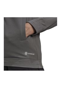 Gray athletic pullover with a smooth texture, features a side pocket and AEROREADY branding printed in white near the hem.