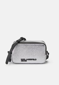 Borsa a tracolla metallica argento con forma rettangolare, dettaglio del logo nero e tracolla regolabile. Presenta una chiusura con zip e una superficie texture.
