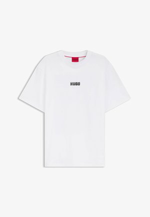 T-shirt en coton blanc avec manches courtes, col rond et logo "HUGO" brodé en argent sur la poitrine. Texture lisse, coupe décontractée.