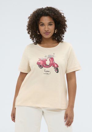 Donna con capelli ricci che indossa una maglietta color crema a maniche corte con monopattino rosa e la scritta "ciao bella!", abbinata a pantaloni chiari.