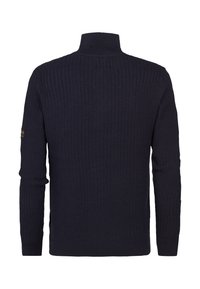 Navyblauwe gebreide trui met een hoge kraag, voorzien van een gestreept patroon en zijsplitten. Lange mouwen met een merkembleem op de mouw.