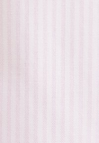 Tissu rose clair avec un motif subtil de rayures verticales créé par de petits points cousus uniformément espacés sur la surface.