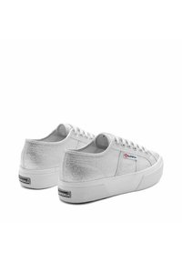 Scarpe da ginnastica in tela argento metallico con finitura testurizzata, suola piatta in gomma bianca e sei occhielli con chiusura con lacci.