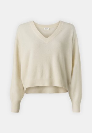 V-neck, cropped sweater in soft, cream-colored knit fabric. Features relaxed, long sleeves and ribbed cuffs and hem.
