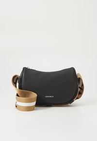 Svart skinn crossbody-veske med buet form, med en stoffrem i tan med hvite striper og logo-detaljer på fronten.