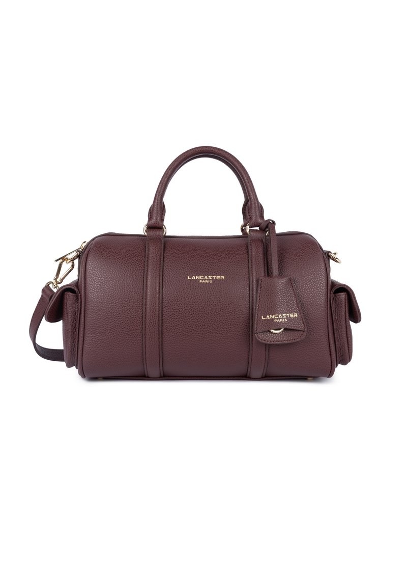 Sac à main en cuir bordeaux avec quincaillerie dorée, doubles anses supérieures et bandoulière amovible. Présente un logo de marque en relief et une texture.