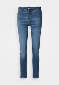 Sötétkék farmernadrág, slim fit szabású, klasszikus öt zsebes dizájnnal, cipzáras előrész és enyhe fakulással a comboknál.