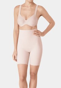 Reggiseno in tessuto a coste di un delicato rosa, con spalline larghe, abbinato a pantaloni shapewear a vita alta, creando una silhouette liscia.