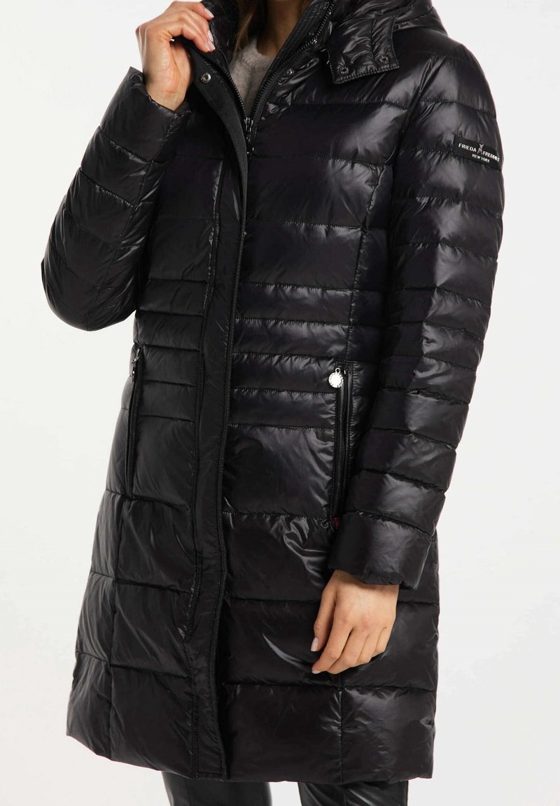 Zwarte pufferjas met horizontaal gestikte ontwerp, voorzien van een hoge kraag, ritszakken aan de zijkanten en een glanzende afwerking.