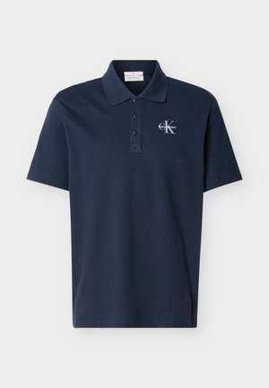 Polo bleu marine à manches courtes avec trois boutons et logo blanc Calvin Klein sur le côté gauche de la poitrine.