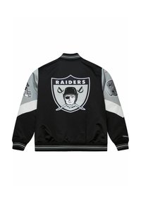 Schwarze Bomberjacke mit grauen Ärmelakzenten, mit einem großen "Raiders"-Logo auf dem Rücken und kleinen Logo-Patches an den Ärmeln. Rippbündchen und Kragen.