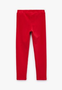 Rote Leggings aus weichem, dehnbaren Stoff mit einem elastischen Bund, die eine glatte Textur und eine enganliegende Form haben und an den Knöcheln enden.