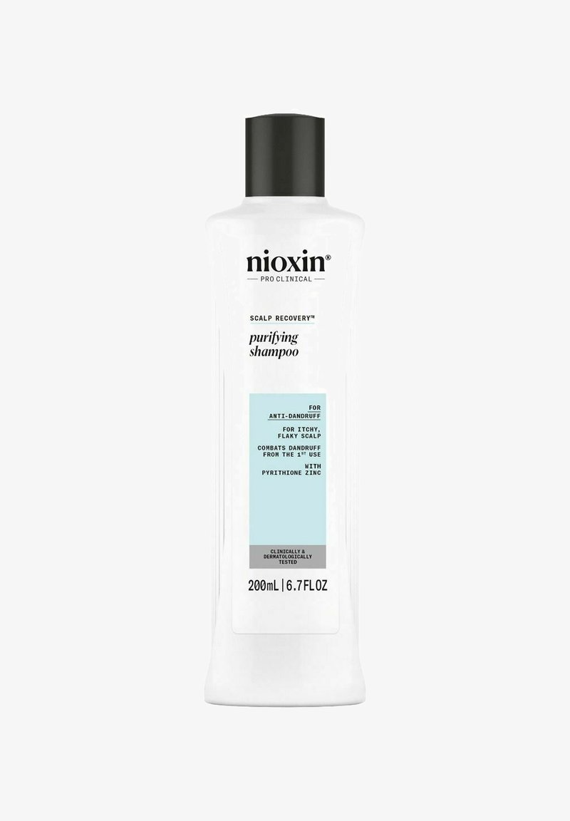 Heldere plastic fles van Nioxin Scalp Recovery Purifying Shampoo. Wit met zwarte dop, lichtblauwe label, tekst die de anti-roos voordelen beschrijft.