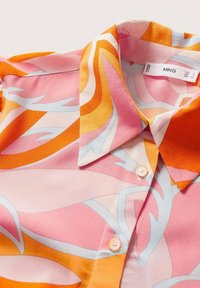 Blusa a maniche corte con un motivo astratto nei colori rosa, arancione e blu, realizzata in tessuto leggero, con colletto classico e chiusura con bottoni.