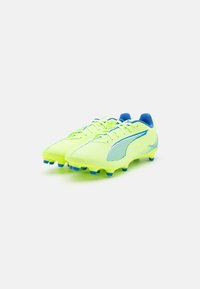 Crampons de football jaunes avec des accents bleus, design léger, surface texturée, dotés d'un laçage et de pitons moulés pour une traction optimale.