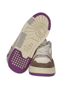 Sneaker con una toma in pelle crema e accenti in suede grigio. Suola in gomma viola, motivo testurizzato e branding prominente sulla suola.