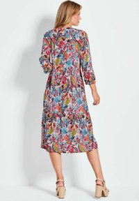 Bloemrijke midi-jurk met lange mouwen, in levendige kleuren zoals roze, blauw en groen, en een gelaagde zoom. Lichte stof met een losse pasvorm.