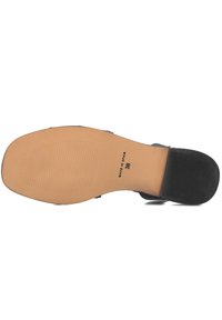 Zwarte schoenzool met gestructureerde grippatronen, beige rubberconstructie en reliëf "Made in Spain" label. Maat 38 zichtbaar.
