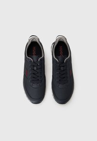 Navy blue sneakers with fabric upper, lace-up design, gray accents on collar, and textured rubber sole. Logo visible on insole.