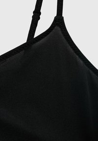 Crni bralette izbliza, napravljen od glatkog materijala s podesivim trakama i ravnim dekolteom. Teksturna šavovi vidljivi duž rubova.