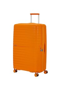 Valigia rigida arancione con un design testurizzato e scanalato, dotata di manico telescopico e quattro ruote per la mobilità.