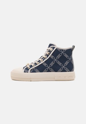 Højt snøresko med marineblåt monogramstof, hvid sål, hvide snørebånd og "Michael Kors" præget på siden af sålen.