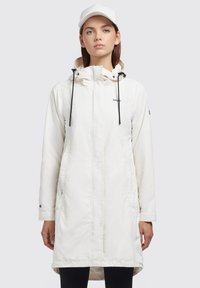 Bílá nepromokavá parka s kapucí, zipovým zapínáním, stahovacími šňůrkami a bočními kapsami. Hladká textura, délka po střední stehna, minimalistický design.