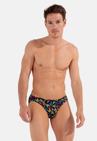 Bunte Schwimmbrieftaschen mit einem schwarzen Hintergrund und einem Schmetterlingsmuster in lebhaften Farben. Hergestellt aus dehnbaren Materialien, die für Komfort sorgen.