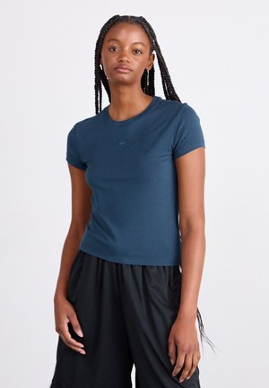 Camiseta de manga corta azul marino hecha de tela suave, con cuello redondo y un pequeño logo de Nike en el pecho, combinada con pantalones cortos de malla negros.