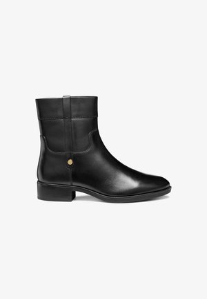 Bottines noires en cuir avec une finition lisse, bout rond, petit talon et détail de patte décoratif. Présente un design simple et un matériel minimal.