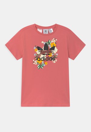 T-shirt rose Adidas avec logo trèfle noir et motif floral multicolore au centre, manches courtes et encolure ronde.