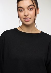 Czarny sweter z dzianiny z szerokim dekoltem i długimi rękawami, charakteryzujący się gładką fakturą i luźnym krojem, odpowiedni do codziennych stylizacji.