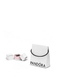Weißes Papiertragetasche mit schwarzem Griff, mit "PANDORA" in Fettdruck. Zwei kleine Kästchen, eines weiß und eines rosa, mit schwarzen Innenseiten und dem Text "PANDORA".