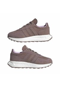 Bruna mockasiner i mocka med tre ränder, vit mellansula och lila akcentfärger på kragen. Rund tå och texturerad gummisul.