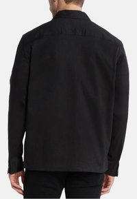 Camicia nera con bottoni, caratterizzata da un colletto classico, maniche lunghe e un'orlo dritto. Realizzata in un tessuto liscio senza motivi visibili.