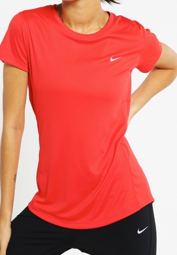 Camiseta deportiva Nike roja de manga corta, cuello redondo y ajuste ceñido. Presenta un pequeño logo gris en el pecho, en la parte superior izquierda.