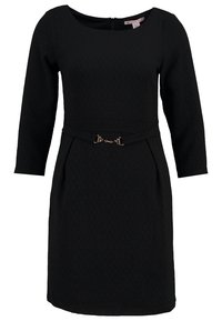 Robe noire longueur genoux avec manches 3/4, encolure bateau et une ceinture fine avec une petite boucle dorée.