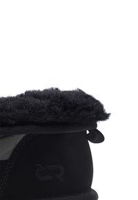 Bota negra con puño de piel texturizada, caña lisa y detalle de logo. Fabricada con materiales sintéticos y forro interior suave.