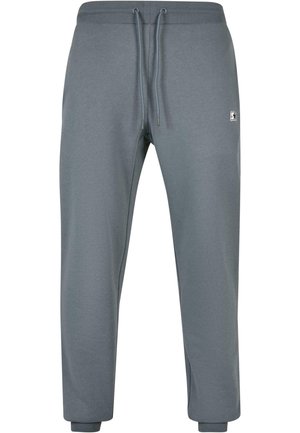 Graue Jogginghosen aus weichem Material, mit elastischem Bund und Kordelzug sowie gerippten Bündchen. Kleines Logo-Detail an der Seite.