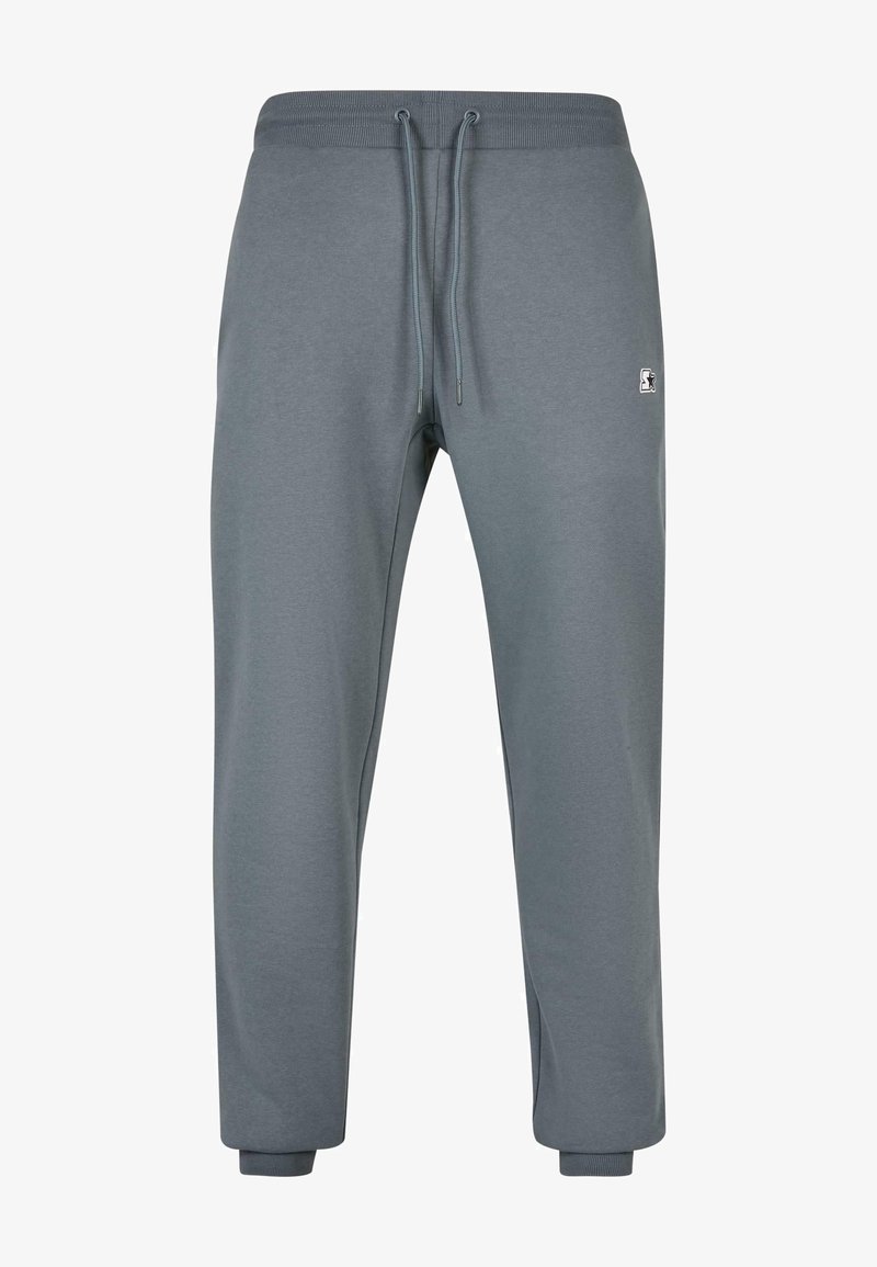 Pelēki sporta bikses, kas izgatavotas no mīksta auduma, ar elastīgu jostasvietu un šņorēm, kā arī ribotām aprocēm. Mazs logotipa akcenti sānos.