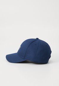 Cappello blu navy con visiera curva, cinturino regolabile e logo ricamato sul davanti. Realizzato in tessuto liscio con dettagli di cucitura.