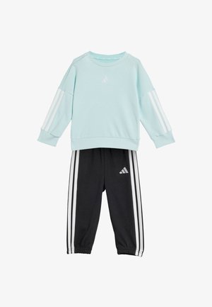 Hellblaues Sweatshirt mit weißen Streifen an den Ärmeln und schwarze Sweatpants mit weißen Streifen und Logo. Weicher Stoff, lässige Passform, elastische Bündchen.