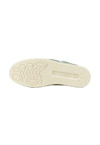 Suela de zapato de goma texturizada en color crema. Presenta patrones circulares y en forma de onda para mayor agarre. Diseño minimalista sin acentos distintivos.