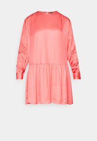Robe en satin rose corail à manches longues, col rond, taille froncée et jupe ample légèrement évasée sur fond uni.