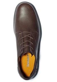 Chaussure à lacets pour homme en cuir marron foncé, bout arrondi et semelle intérieure jaune visible avec le texte de la marque.