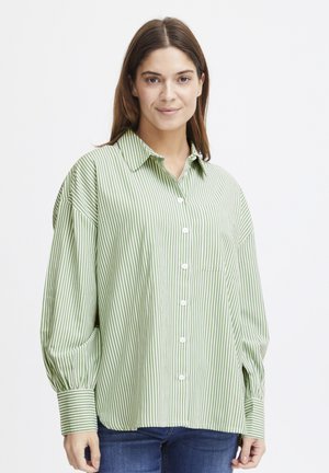 Green and white striped button-up shirt with a collar, oversized sleeves, a chest pocket, and a soft, lightweight fabric texture.